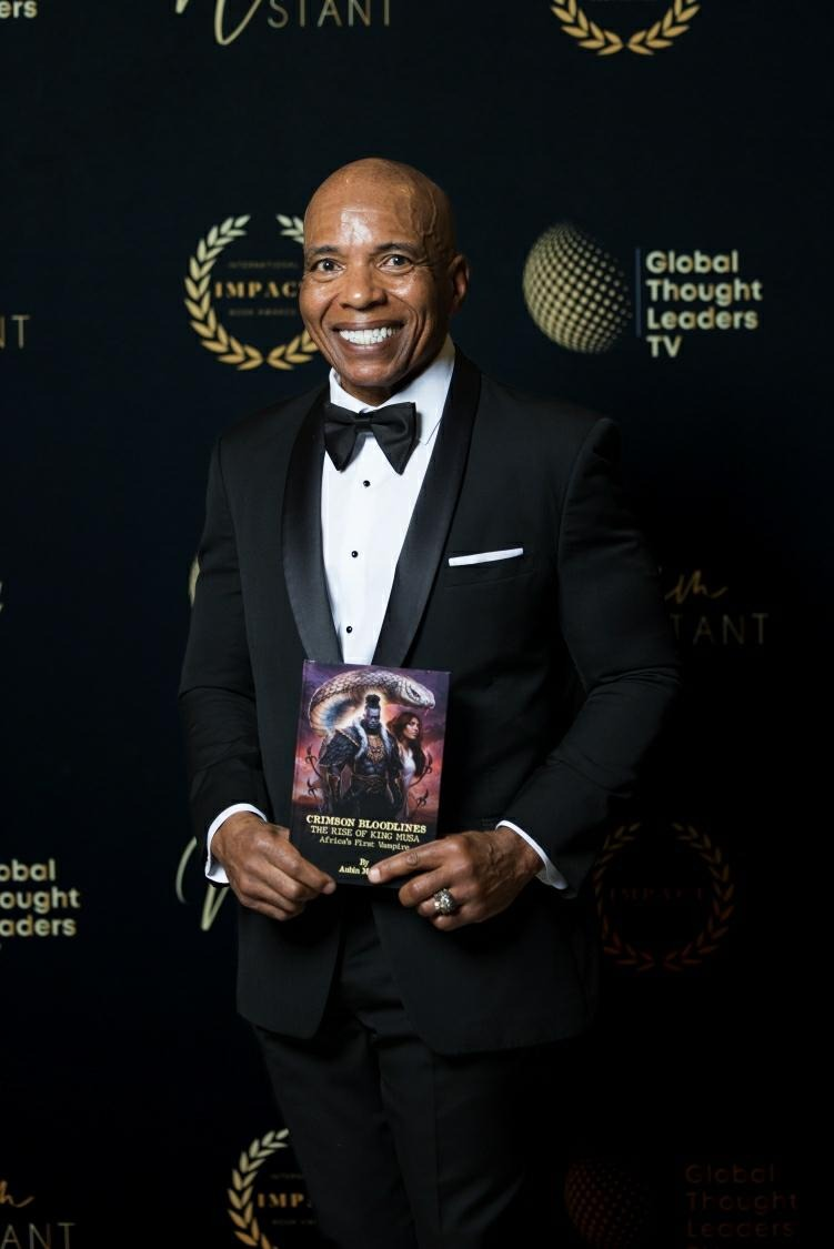 Aubin Jack holding his novel at a formal event